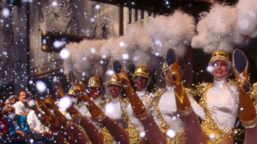 Rockette dancers in gold outfits with feather hats