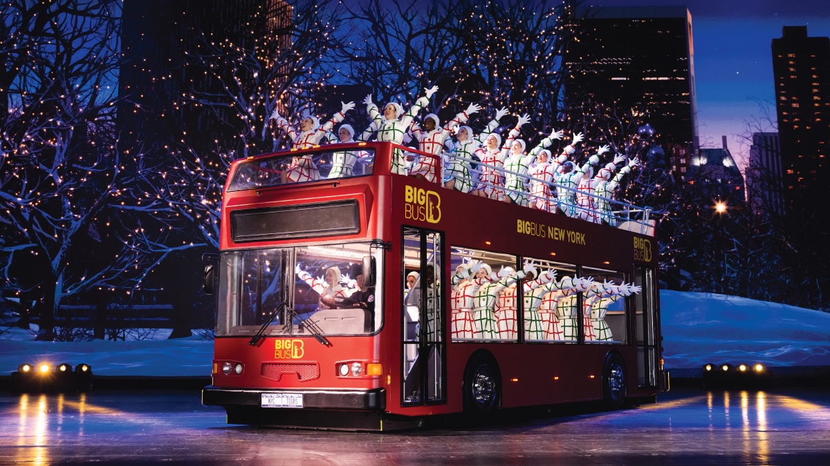 Rockettes dancers on double decker red bus on stage